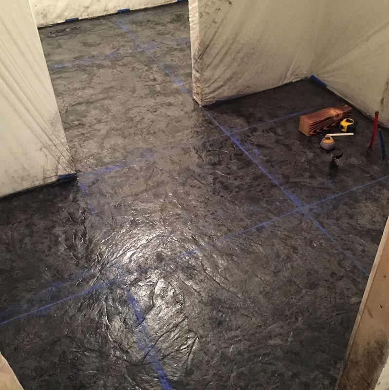 Empty tent-like interior with tarp floor and blue tape lines, plus a toolbox and small items on the right.