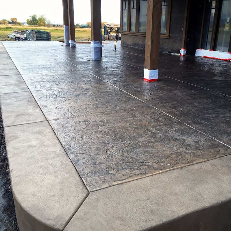 Covered outdoor patio with stained concrete floor and pillars