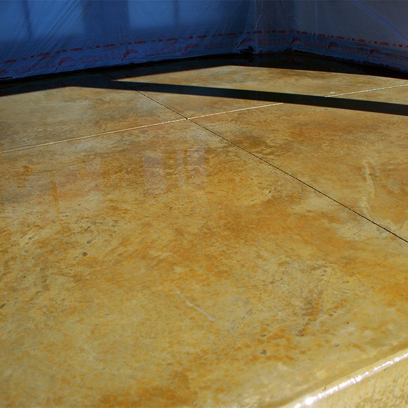 Close-up of a yellow, worn surface with a blue tarp in the background