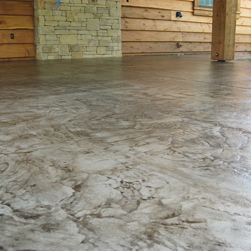Stained concrete floor in a rustic room with stone and wood walls