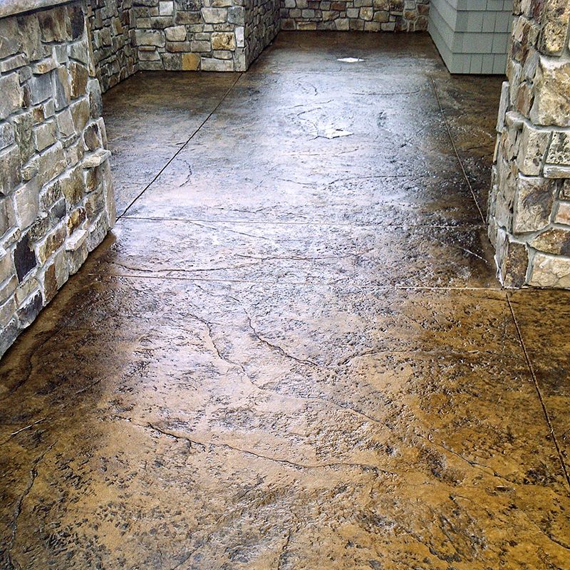 Stone-floored covered porch with stone columns and a wet, glossy surface