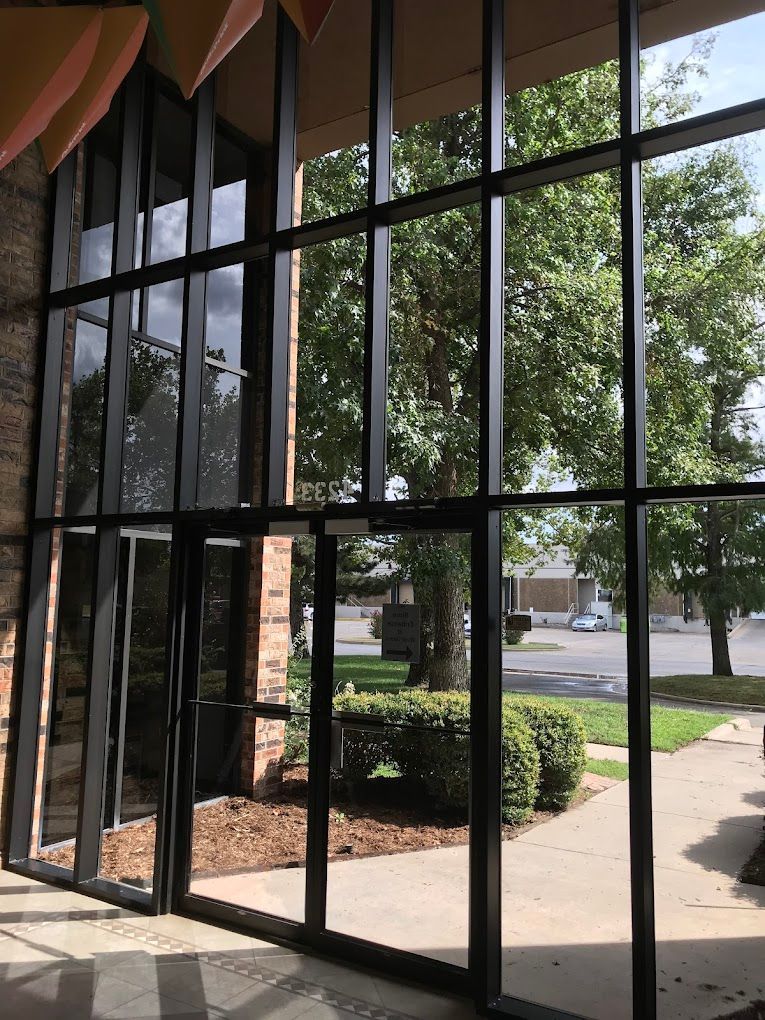 A building with a lot of windows and trees in the background.