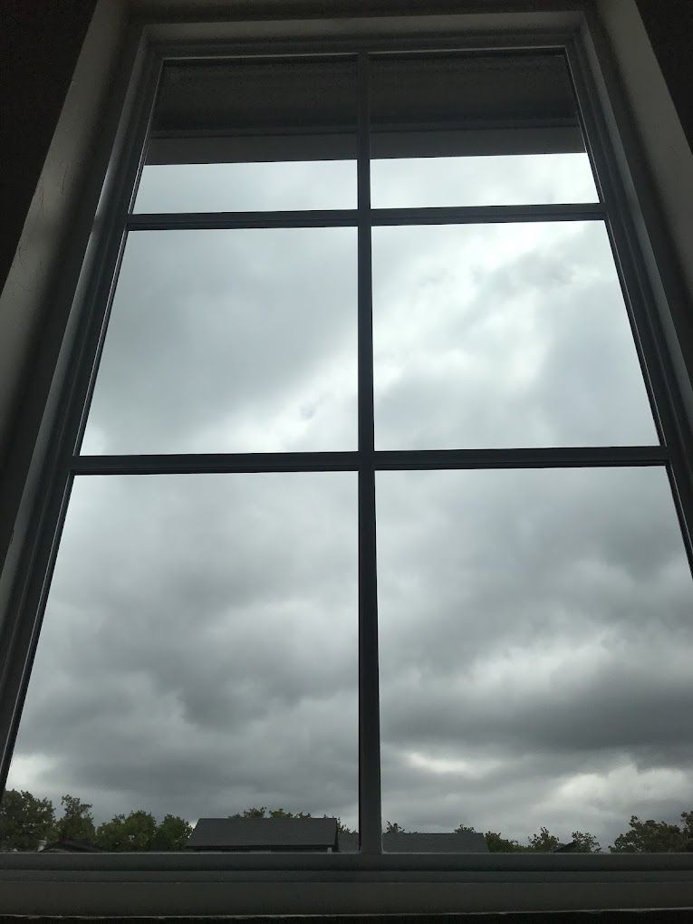 A window with a cloudy sky behind it
