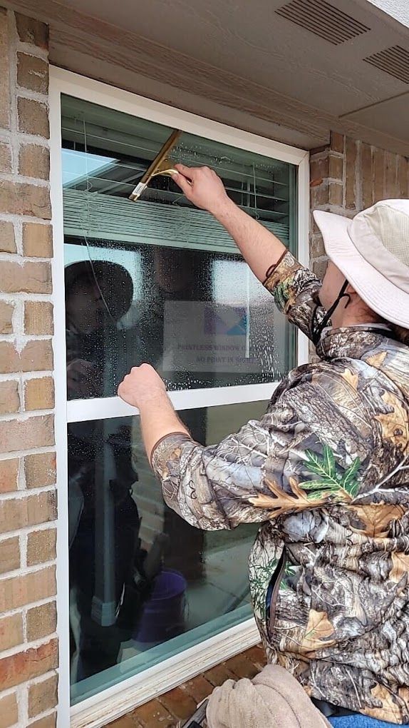 A man is cleaning a window with a squeegee.