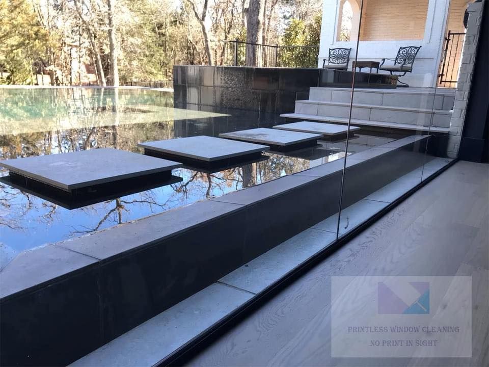 A swimming pool with a glass fence around it