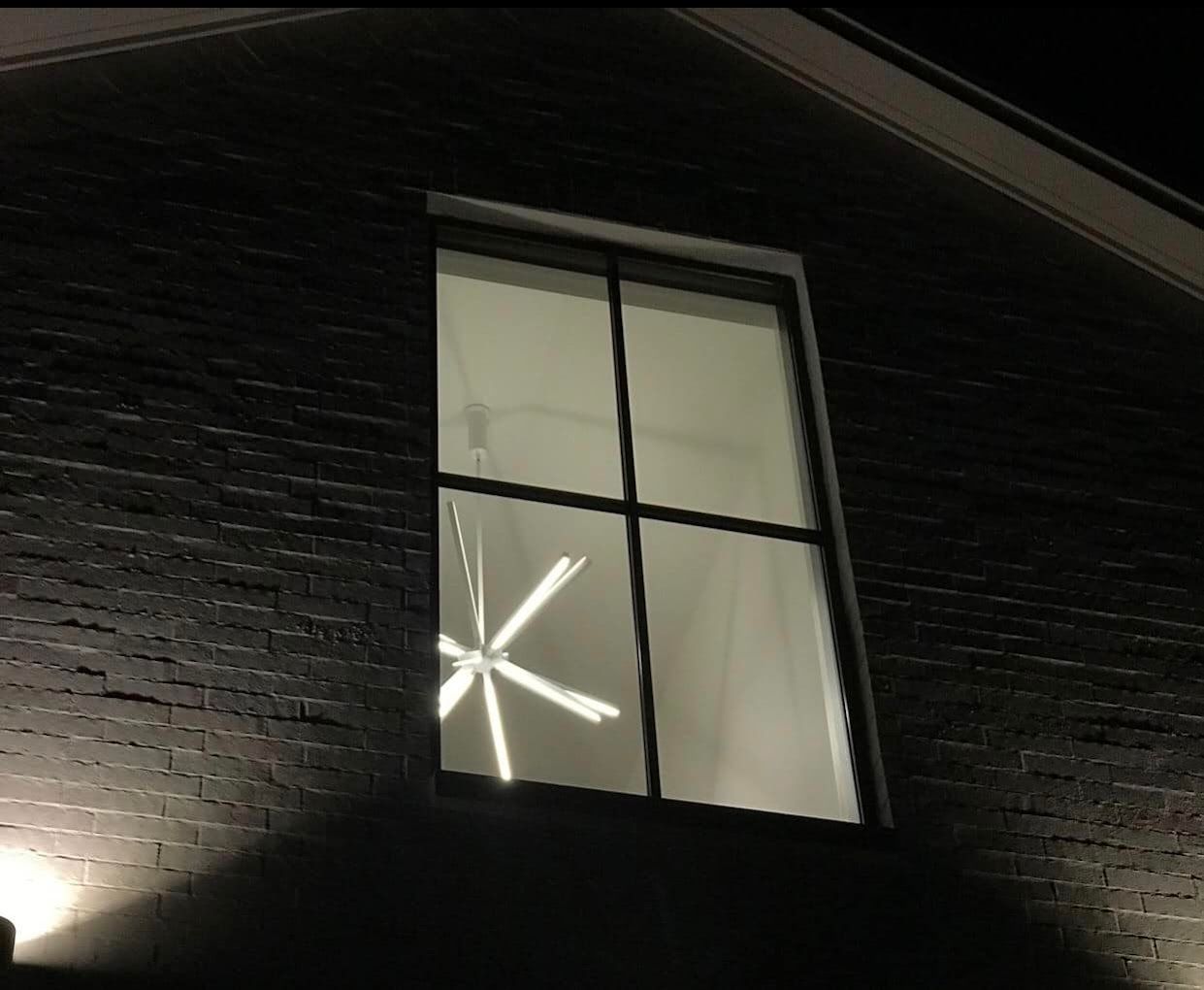 A brick building with a window that is lit up at night