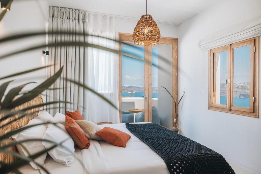 Bedroom with bed, open doors to sea view, rattan lampshade, neutral tones.