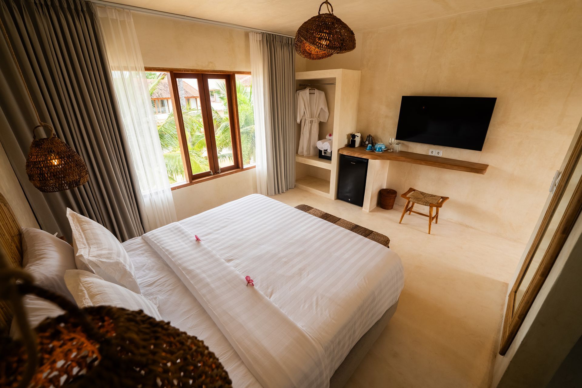 Bedroom with bed, TV, window, wardrobe, and woven light fixtures.