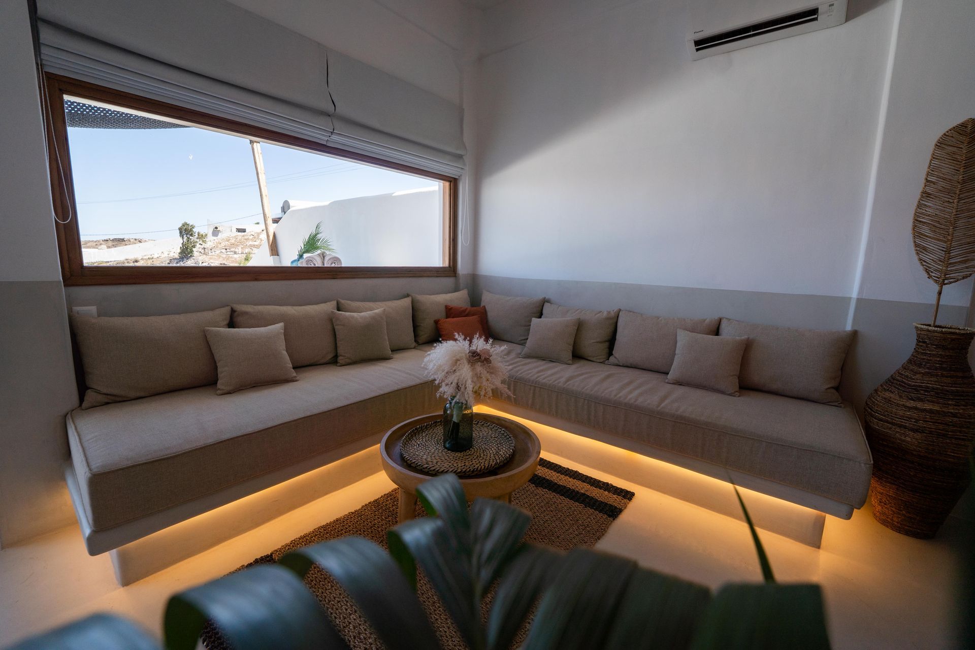 Cozy living space with sectional sofa, large window overlooking a desert landscape. Neutral colors, modern design.