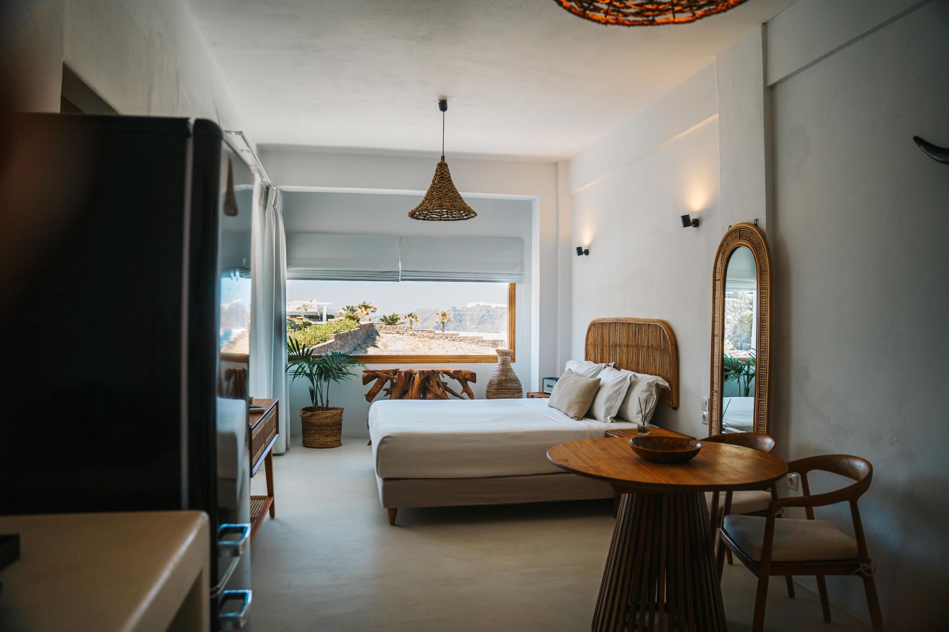 Cozy studio apartment with a bed, dining table, and scenic view.