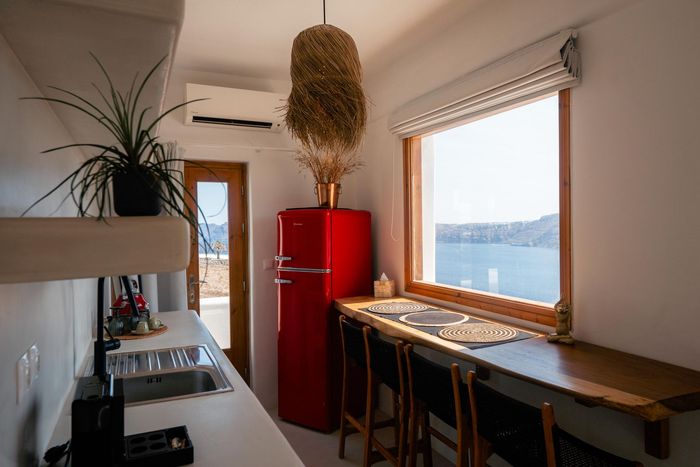 Bright red refrigerator in a modern kitchen with a sea view.