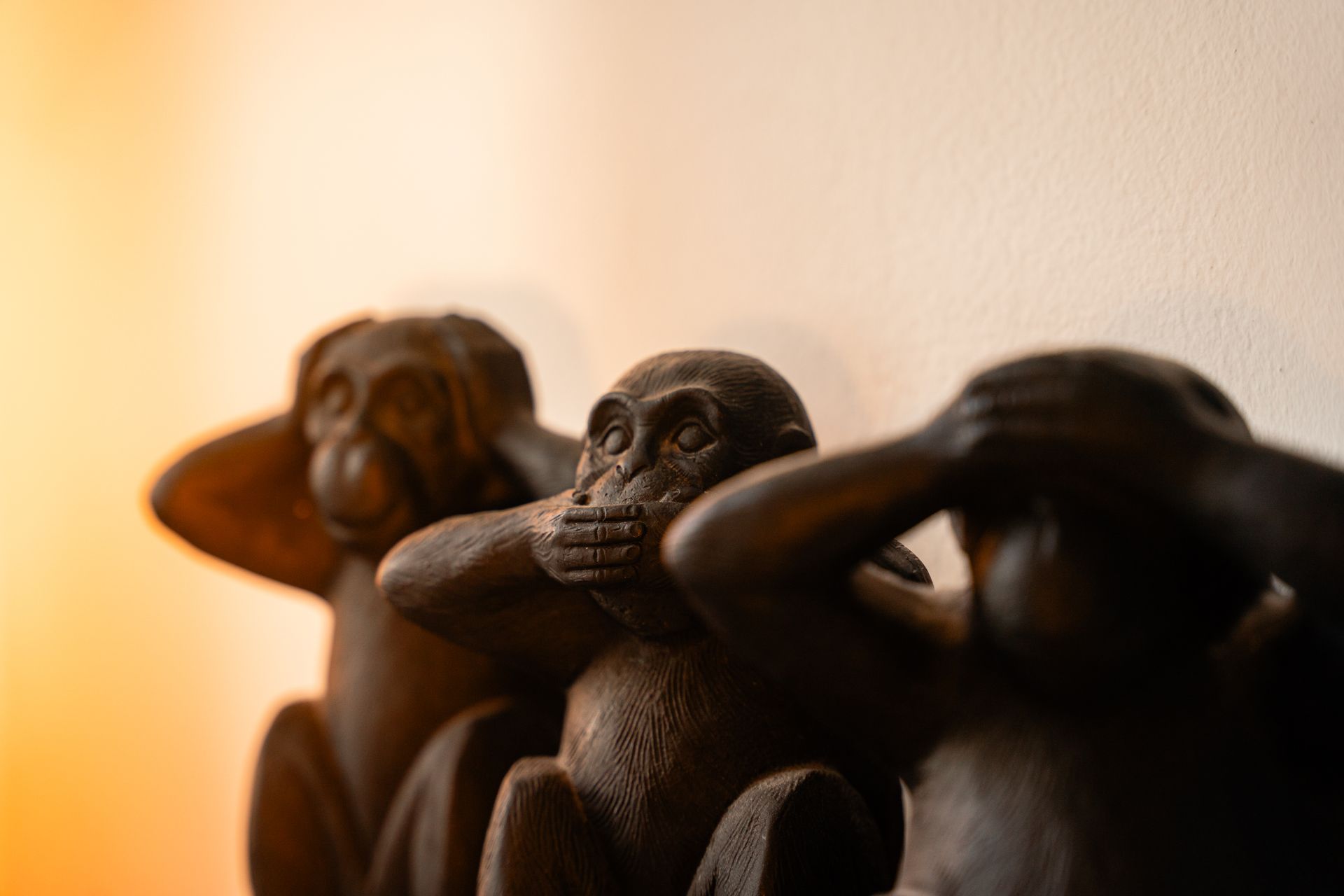 Three wooden monkeys in a row, one covering its ears, one its mouth, and one its eyes.
