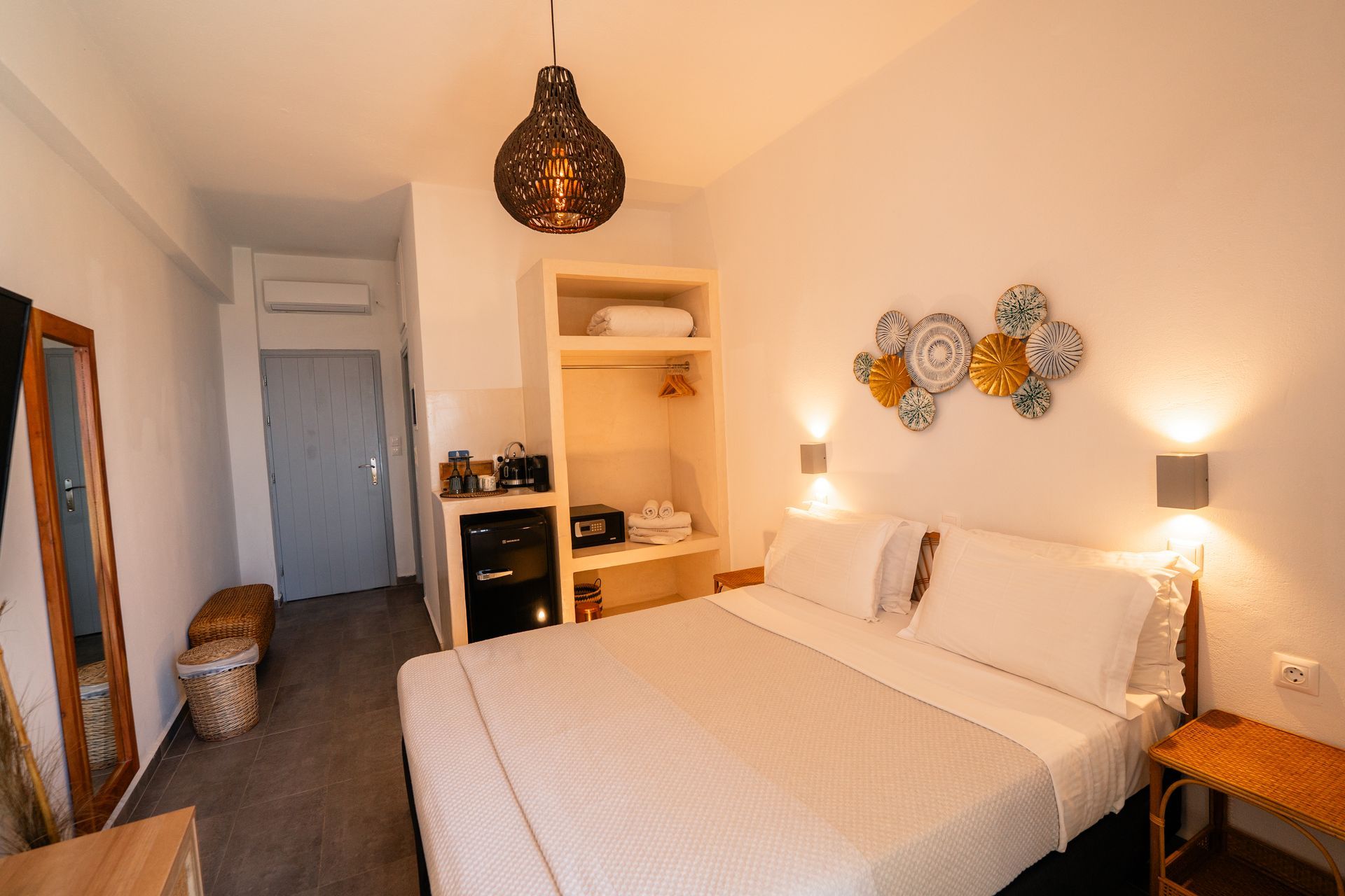 Bedroom with a bed, closet, and wall art. Neutral tones, cozy lighting, and a decorative hanging lamp.