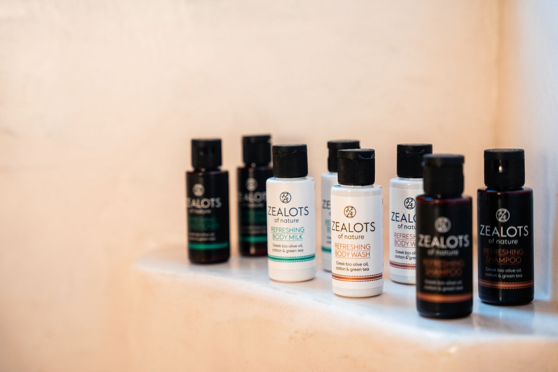 Bottles of Zealots toiletries with black lids in a bathroom setting.