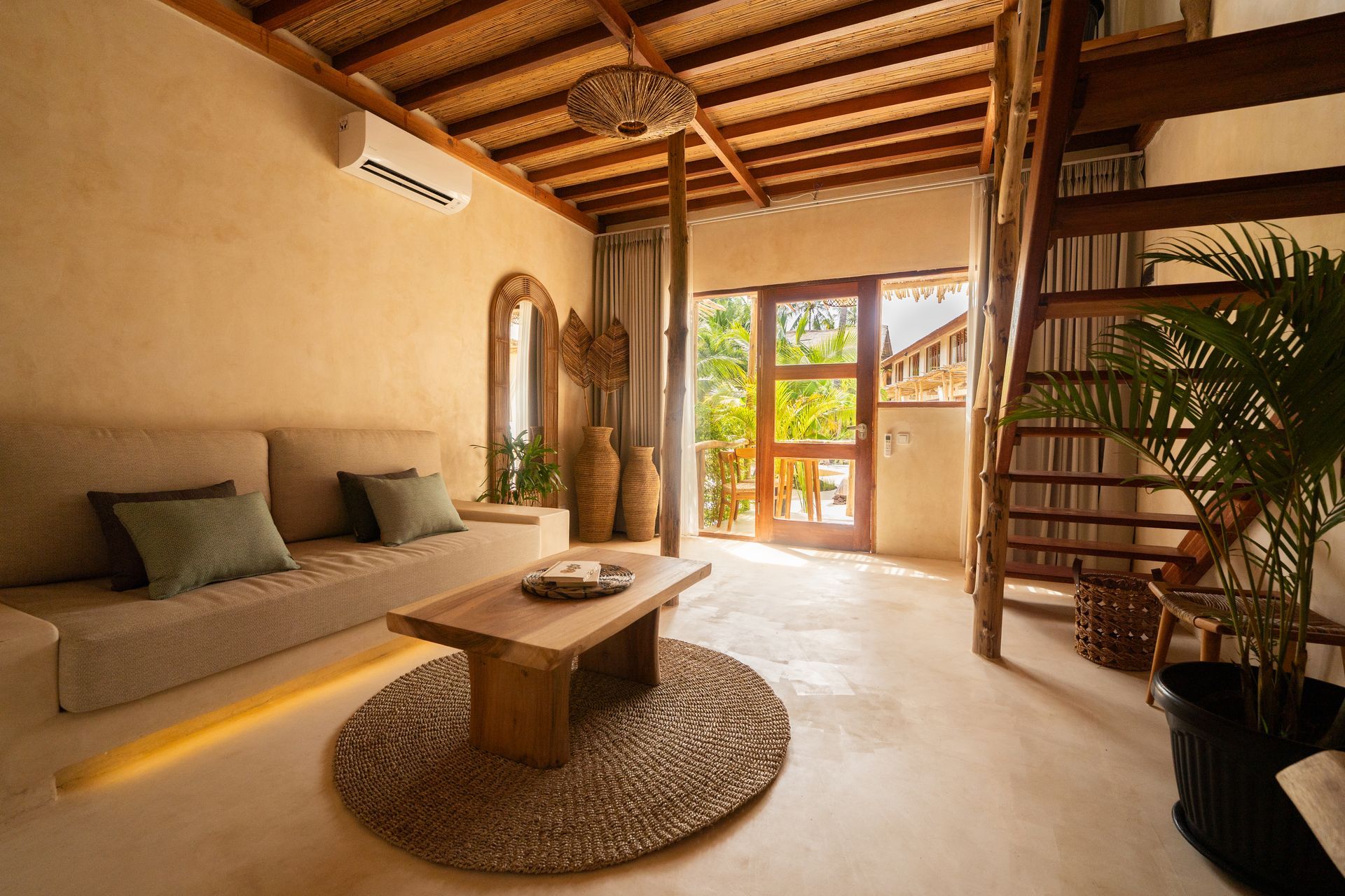 Cozy living space with a sofa, wooden furniture, and open doorway; a warm and inviting atmosphere.