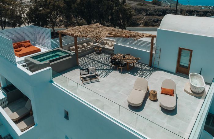 Rooftop terrace with lounge chairs, hot tub, dining area, and ocean view
