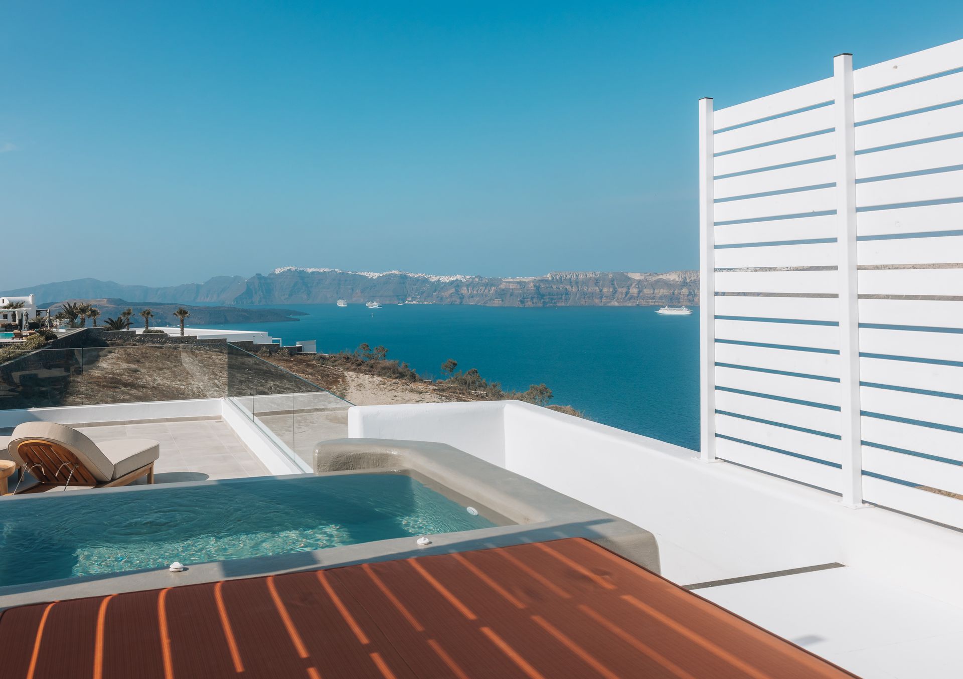 Terrace with pool overlooking the sea, Santorini, Greece. Blue sky, white buildings.