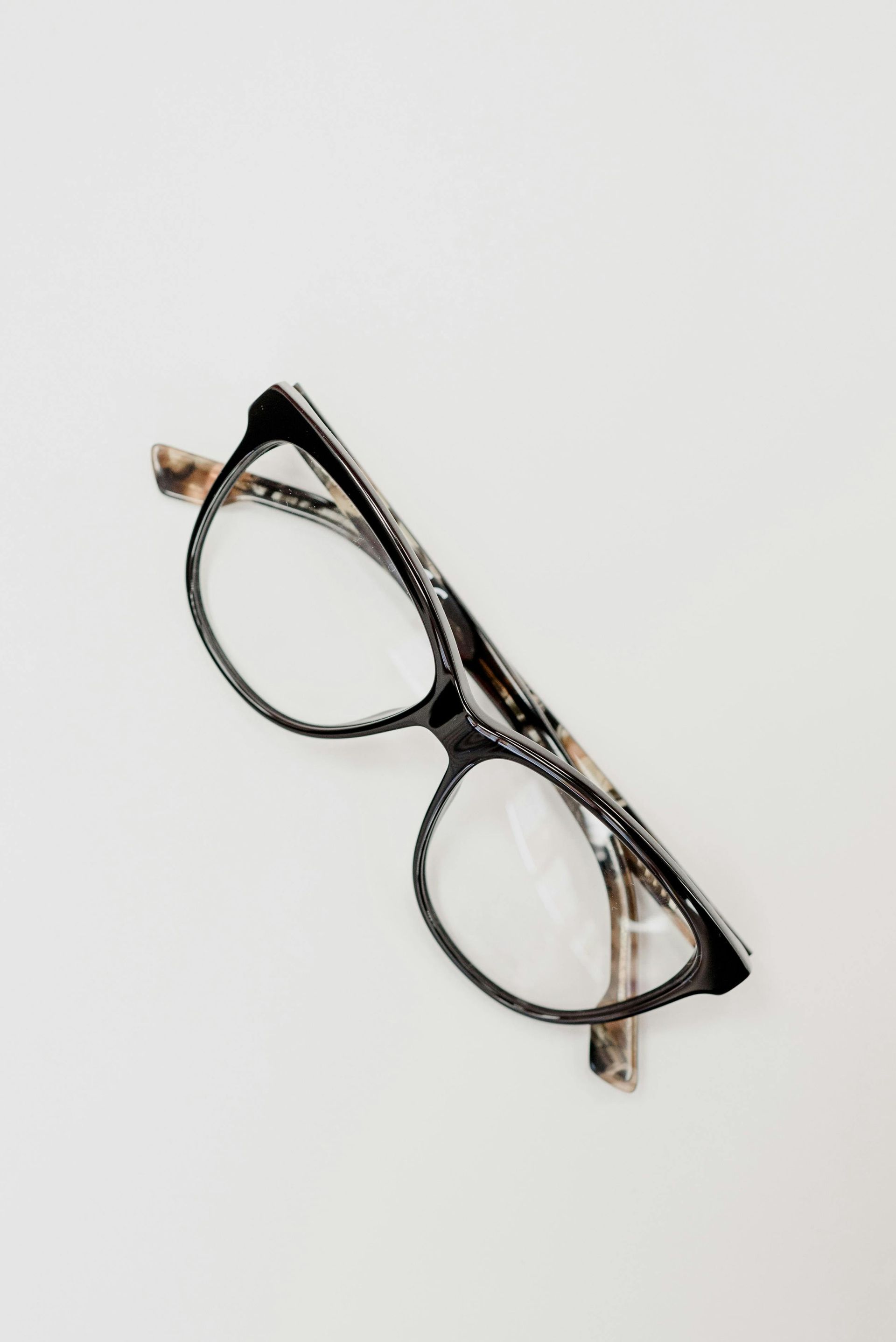 Black and tan eyeglasses on a white background.
