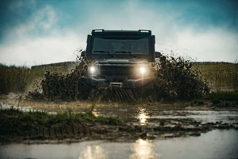 A Truck Is Driving Through A Muddy Puddle — Wilson's Towing In North Toowoomba, QLD
