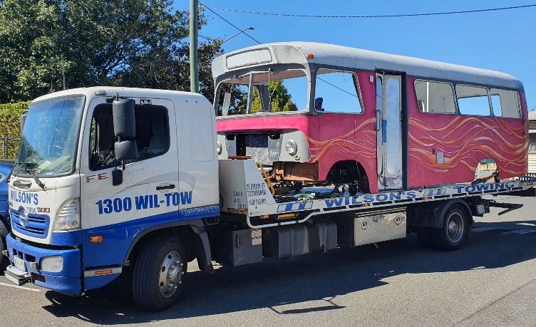 A Tow Truck Is Carrying A Damaged Car On The Back Of It — Wilson's Towing In Warwick, QLD