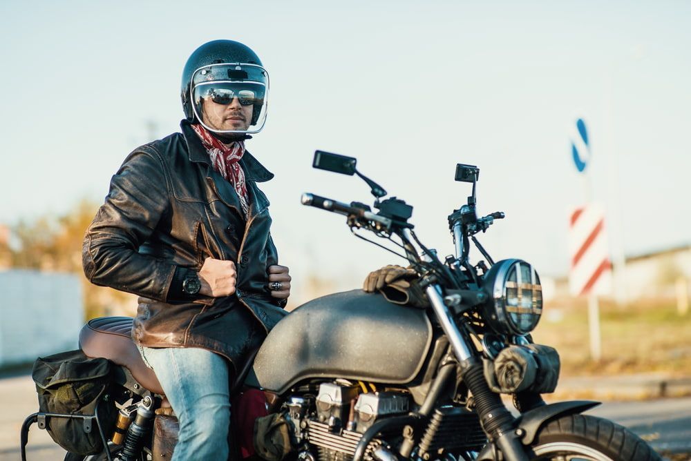 A Man In A Leather Jacket And Helmet Is Sitting On A Motorcycle — Wilson's Towing In Miles, QLD