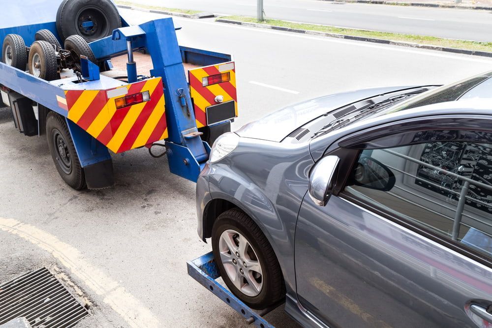 A Car Is Being Towed By A Tow Truck On The Side Of The Road — Wilson's Towing In North Toowoomba, QLD