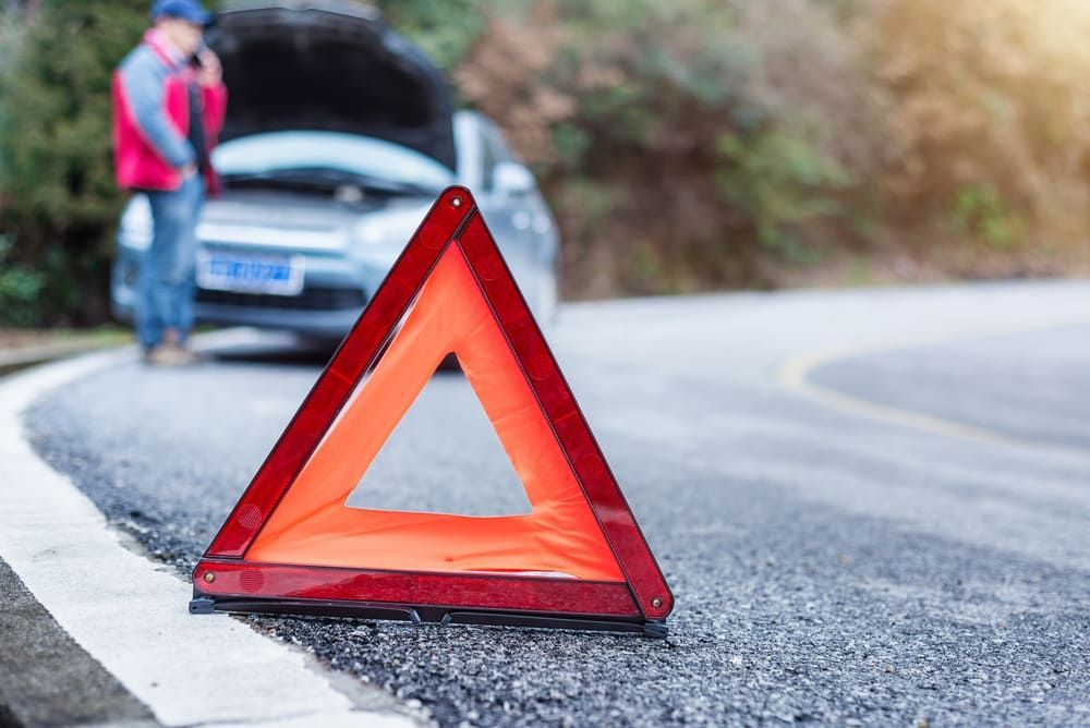 A Man Is Standing Next To A Broken Down Car With The Hood Up — Wilson's Towing In Warwick, QLD