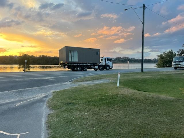 A Tow Truck Is Towing A Container On The Road — Wilson's Towing In North Toowoomba, QLD