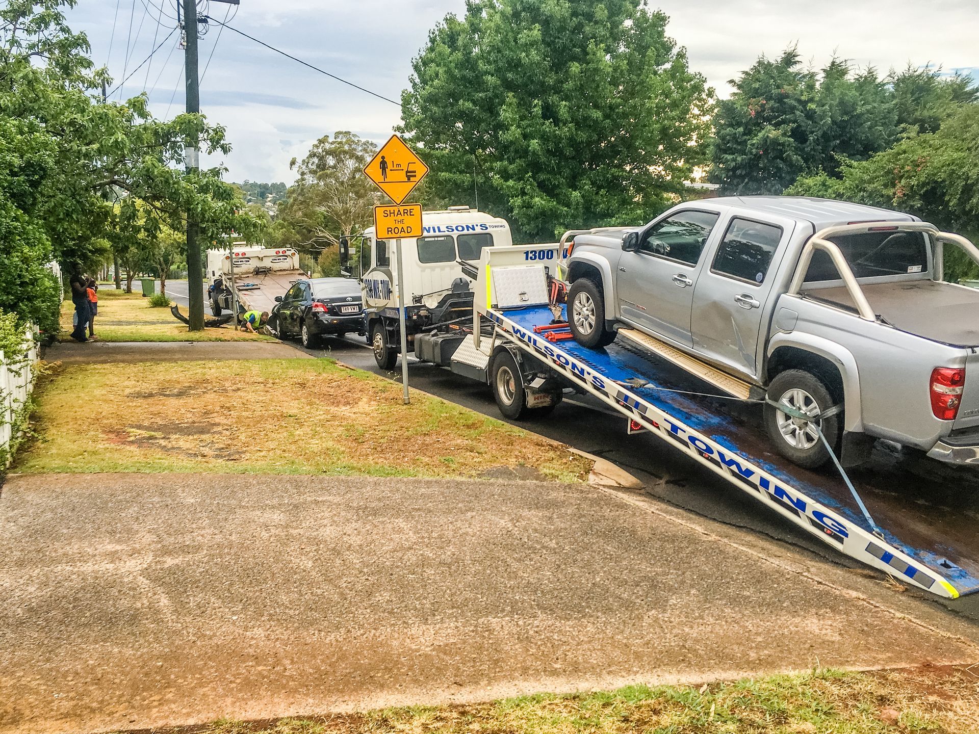 A Car Is Towing A ATV On A Trailer On A Highway — Wilson's Towing In Roma, QLD
