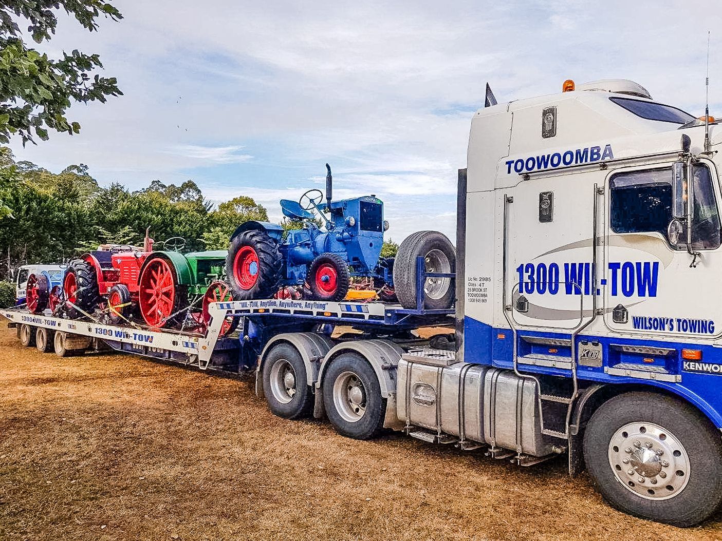 Tow Truck Towing a Blue Tractor — Wilson's Towing In North Toowoomba, QLD