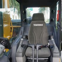 Interior of a Yuchai S35 excavator cabin with operator's seat, controls, and windshield visible.