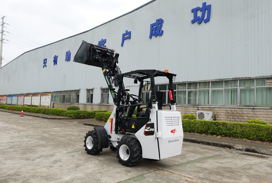 White YUCHAI Z25 compact loader with raised bucket outside a building.