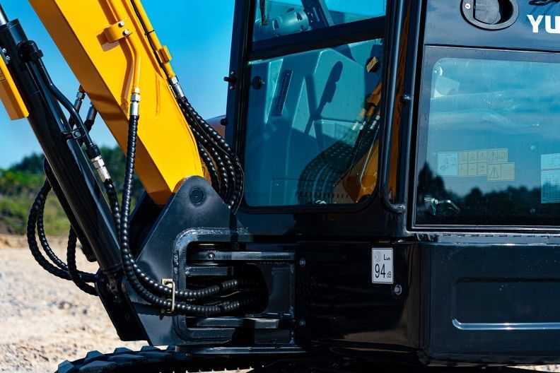 Black and yellow YUCHAI U35 excavator arm and cab details, with hydraulic lines.