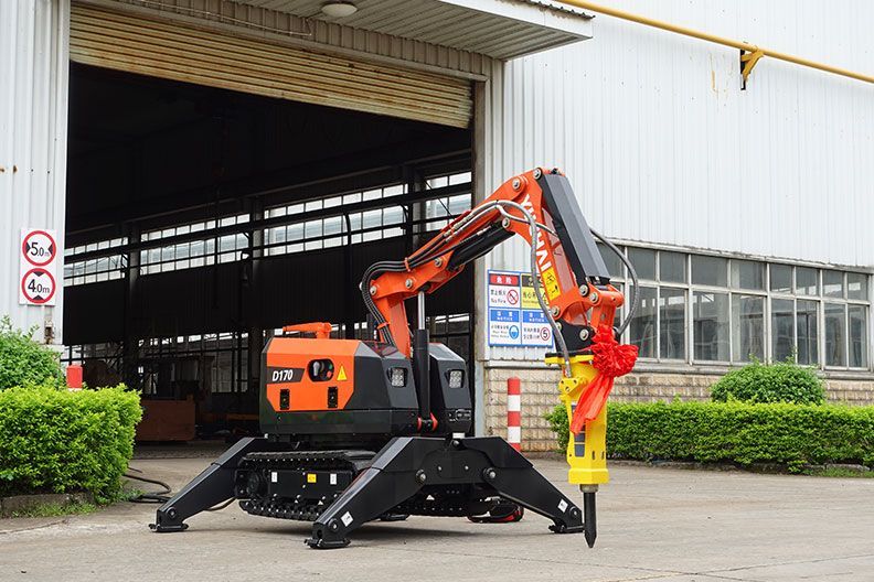Une excavatrice orange et noire équipée d'un marteau-piqueur se trouvait devant une usine.