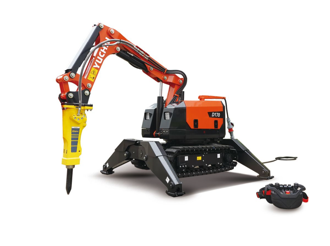 Orange-and-black robotic excavator with a yellow breaker attachment and remote control on a white background