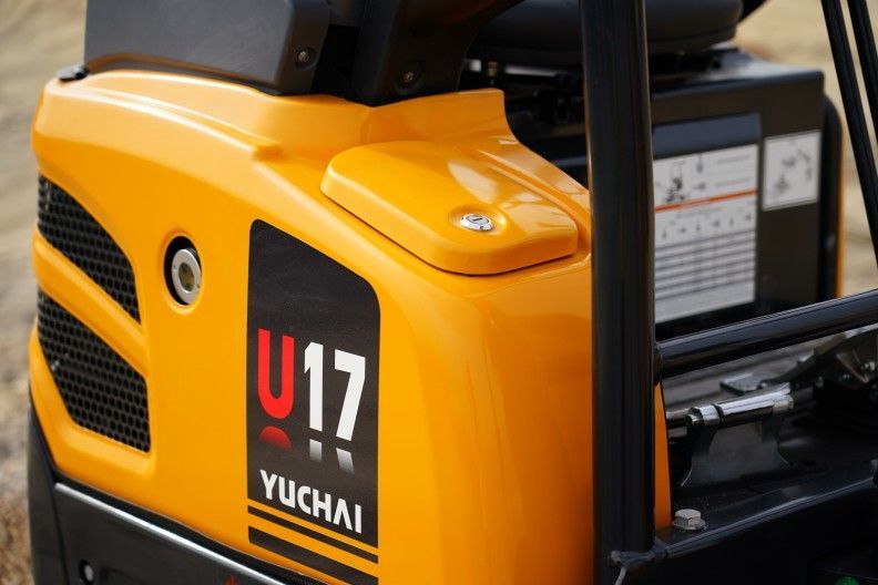Mini-pelle Yuchai U17 jaune, gros plan du carter moteur.