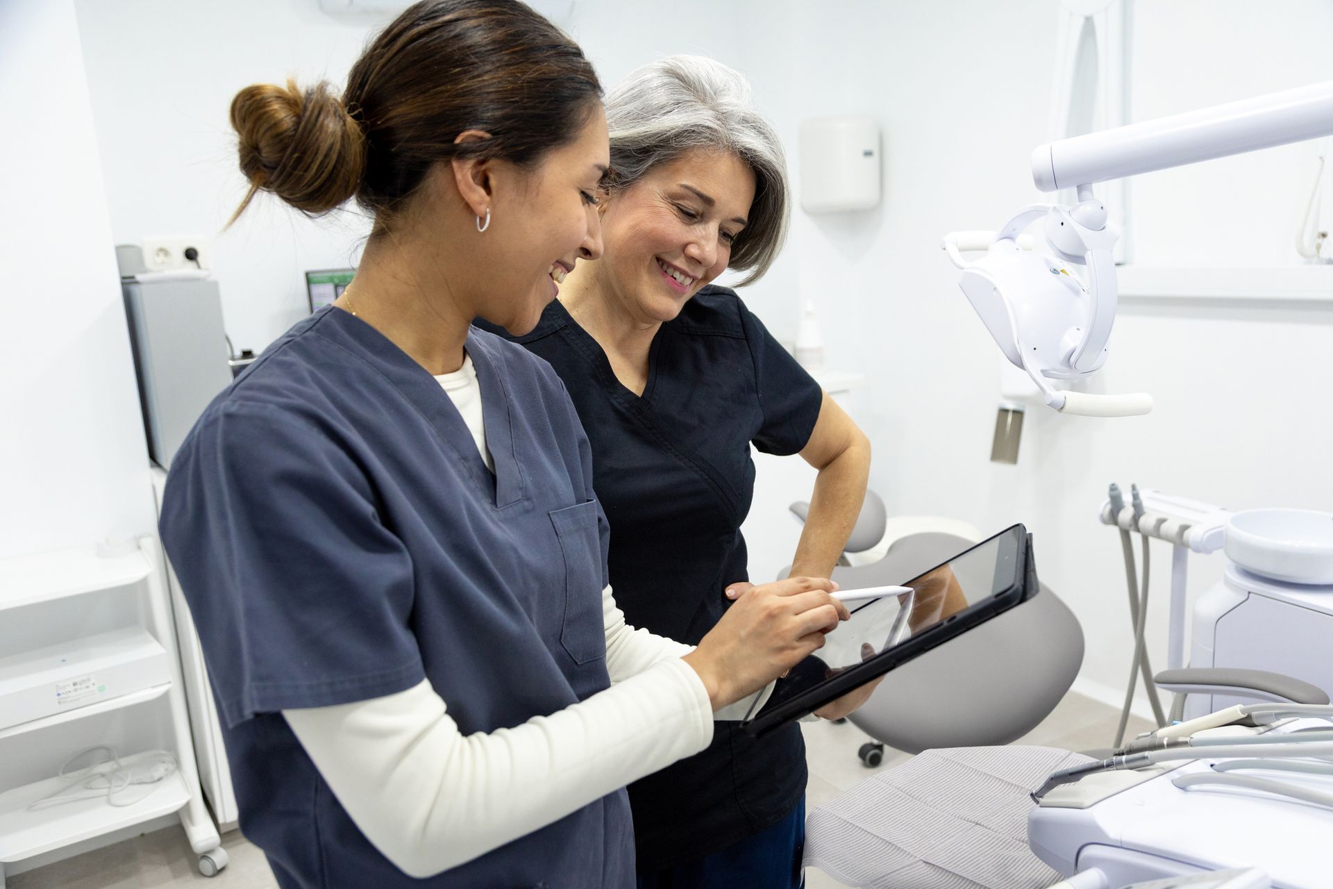 Doctor speaking to a patient in a hospital room. The patient is lying in bed with an IV drip.