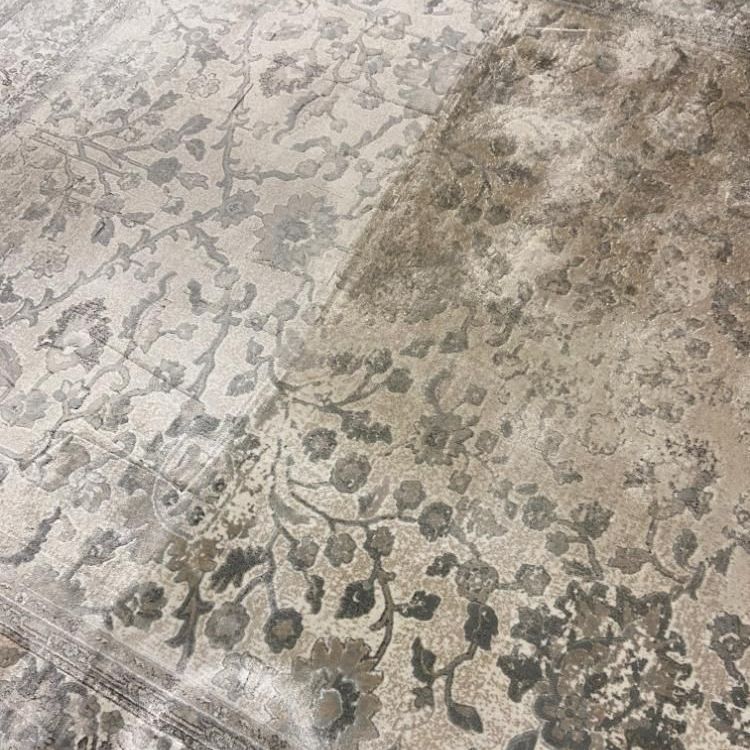 A rug with a floral pattern is being cleaned.