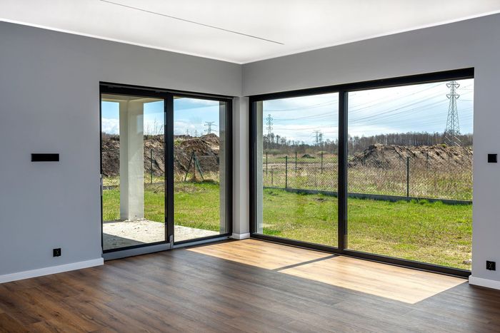 An empty room with a lot of windows and a view of a field.