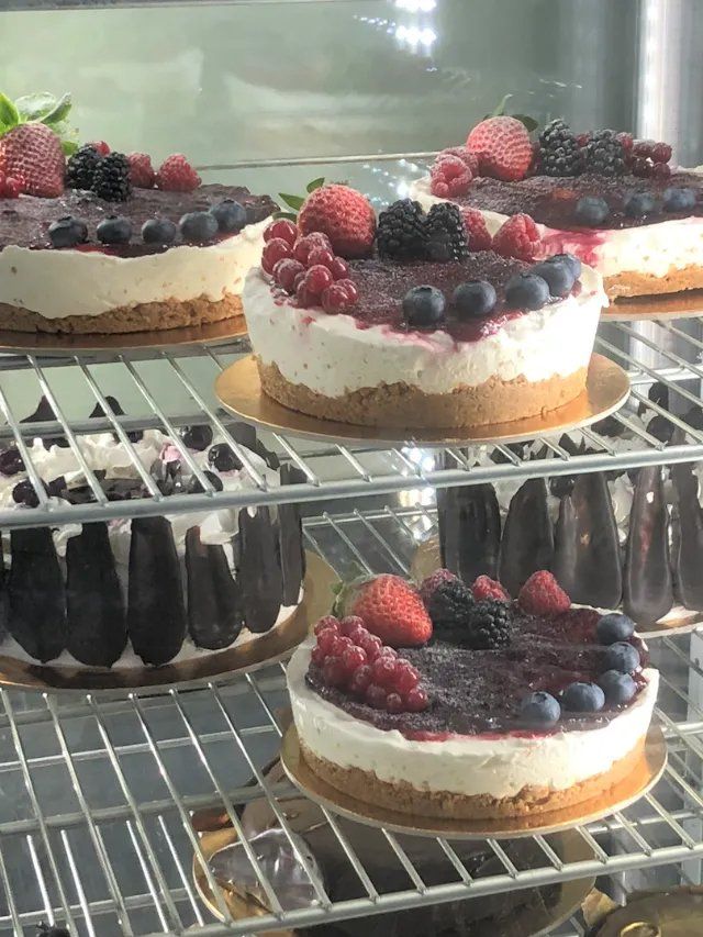 vetrina di una pasticceria con cheesecake ai frutti di bosco