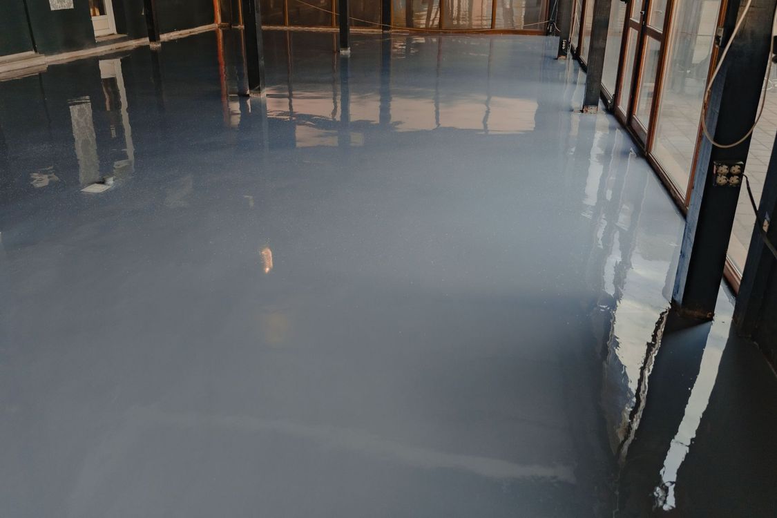 Freshly poured gray concrete floor inside a building under construction