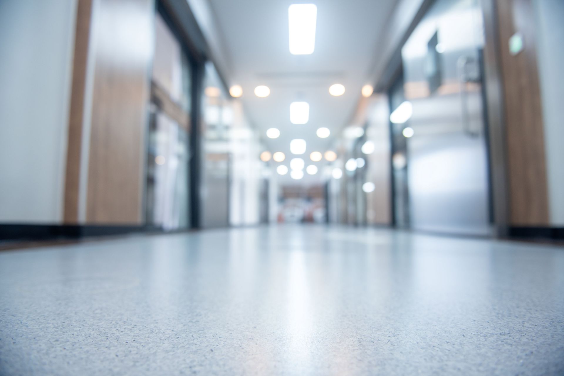 Empty office hallway with bright lights and a blurred floor-level view