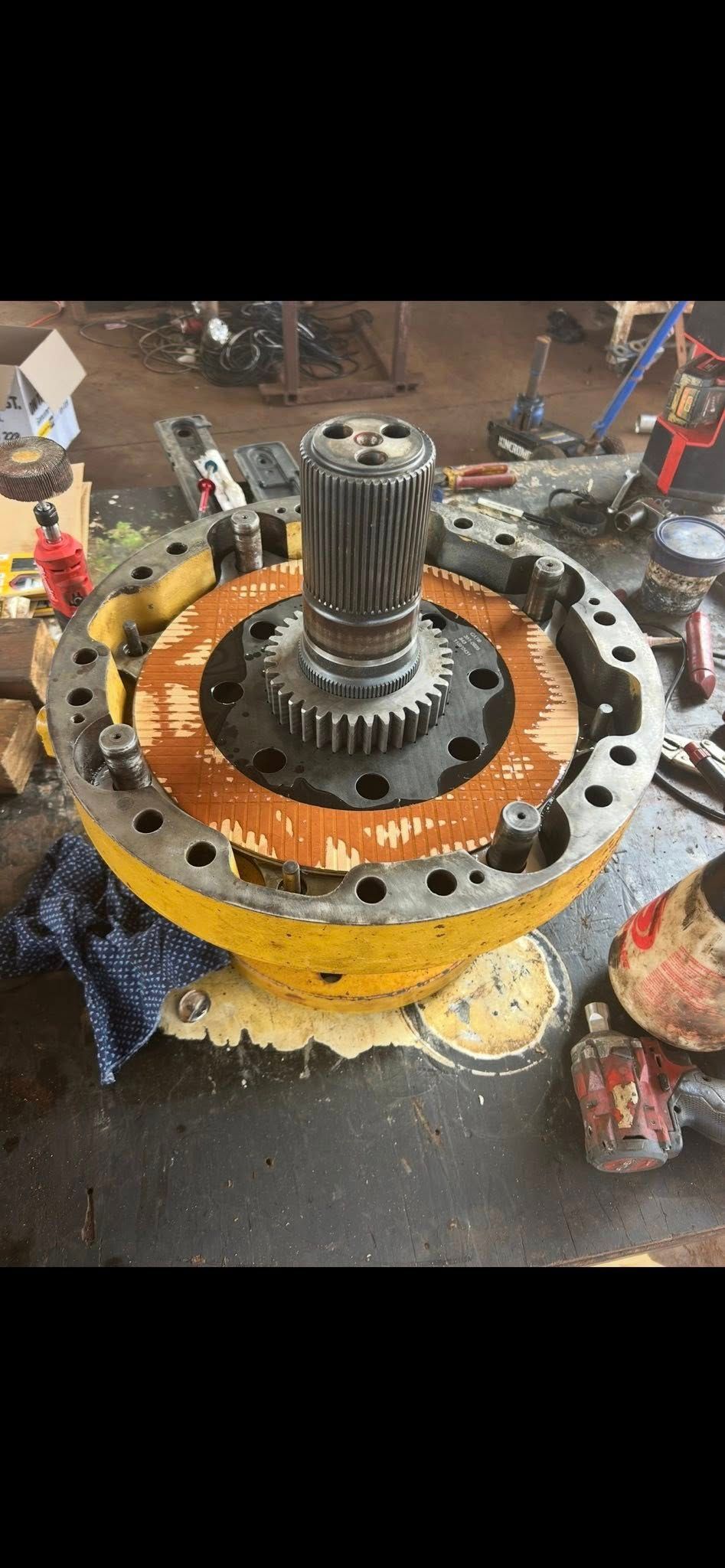 Yellow and black machinery component on a dark surface; rusty orange ring around center with central gear — Full Noise Mechanical in Humpty Doo, NT