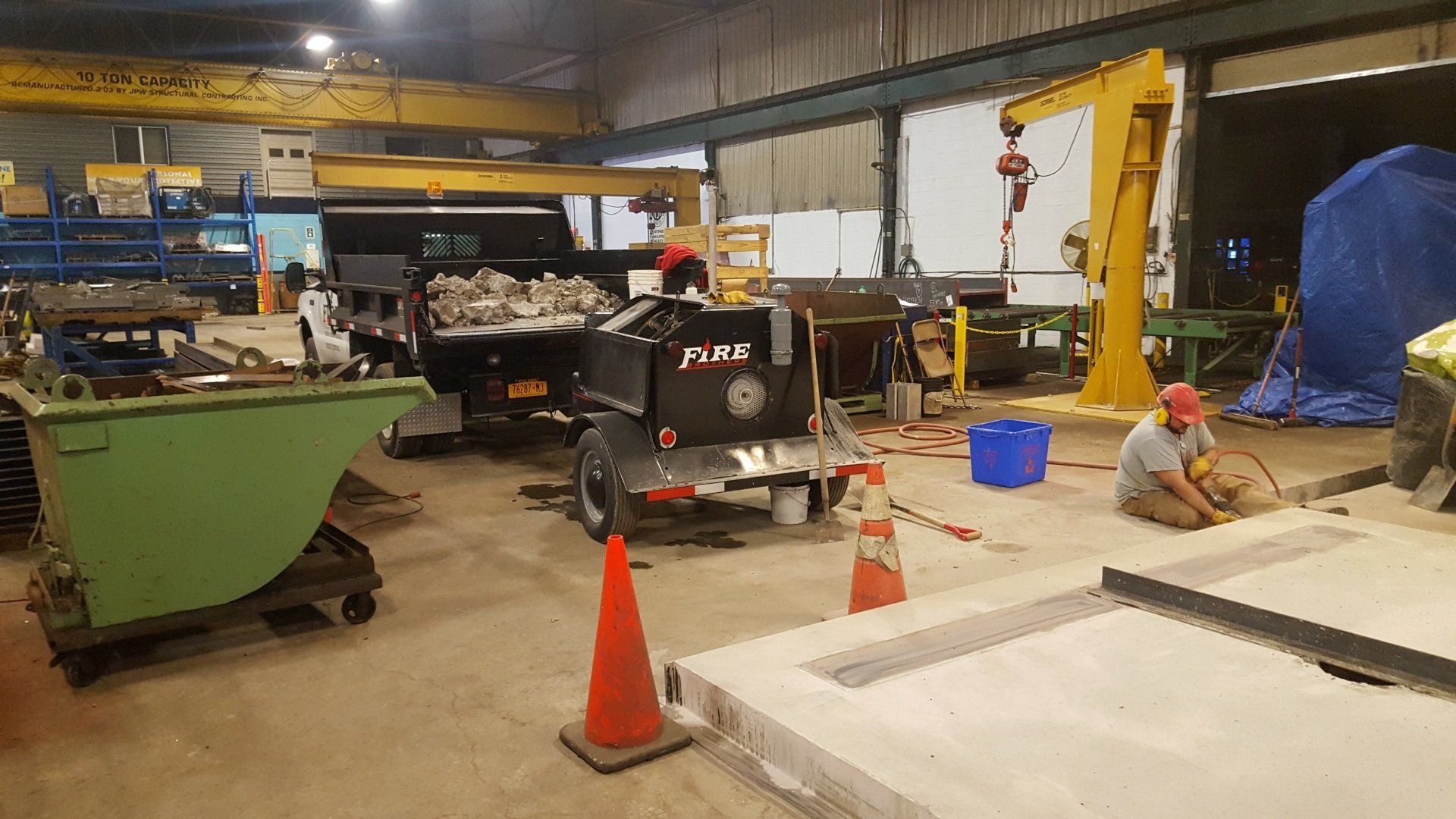 A man is sitting on the floor in a factory.