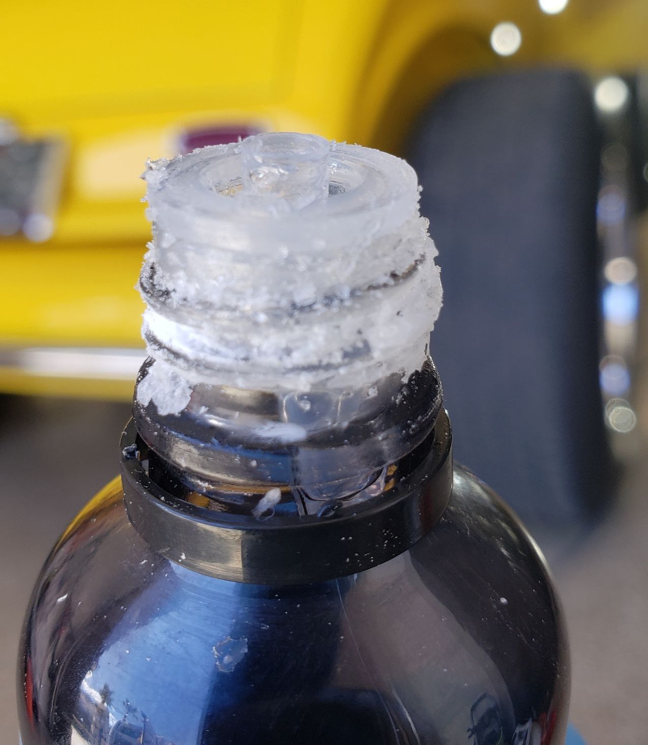 Ceramic coating that has precipitated under the cap. up close of ceramic coating bottle. silicon is hardened on the cap.