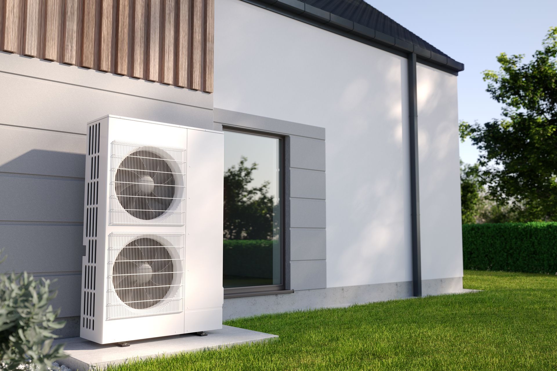 Outdoor heat pump unit beside a modern white house with gray siding and a green lawn