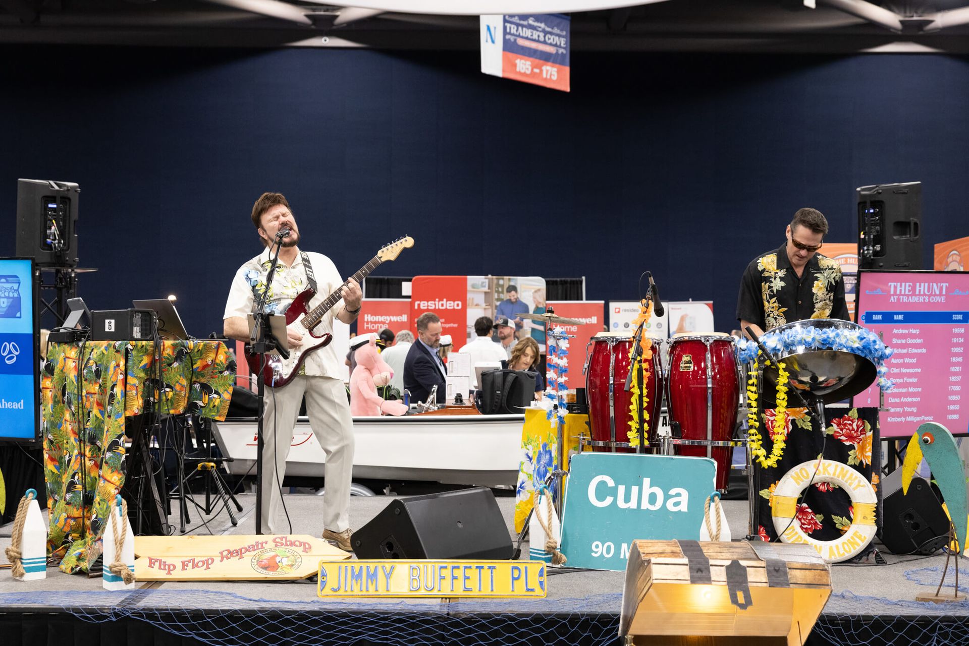 Live band performing on a decorated stage, with guitars, drums, and a Cuba sign in front.