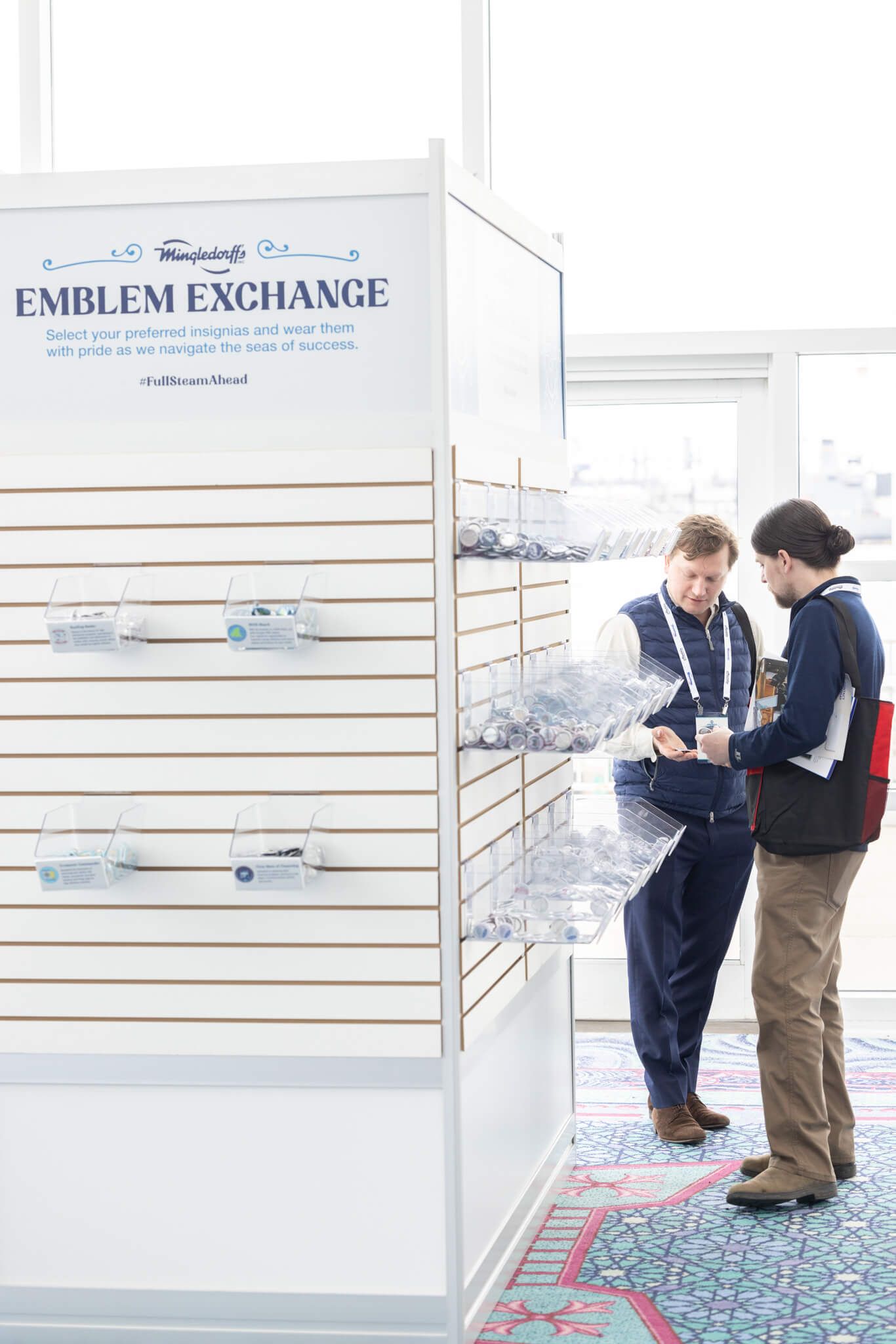 Two people browsing items in a bright white exchange shop with wall shelves and display counter