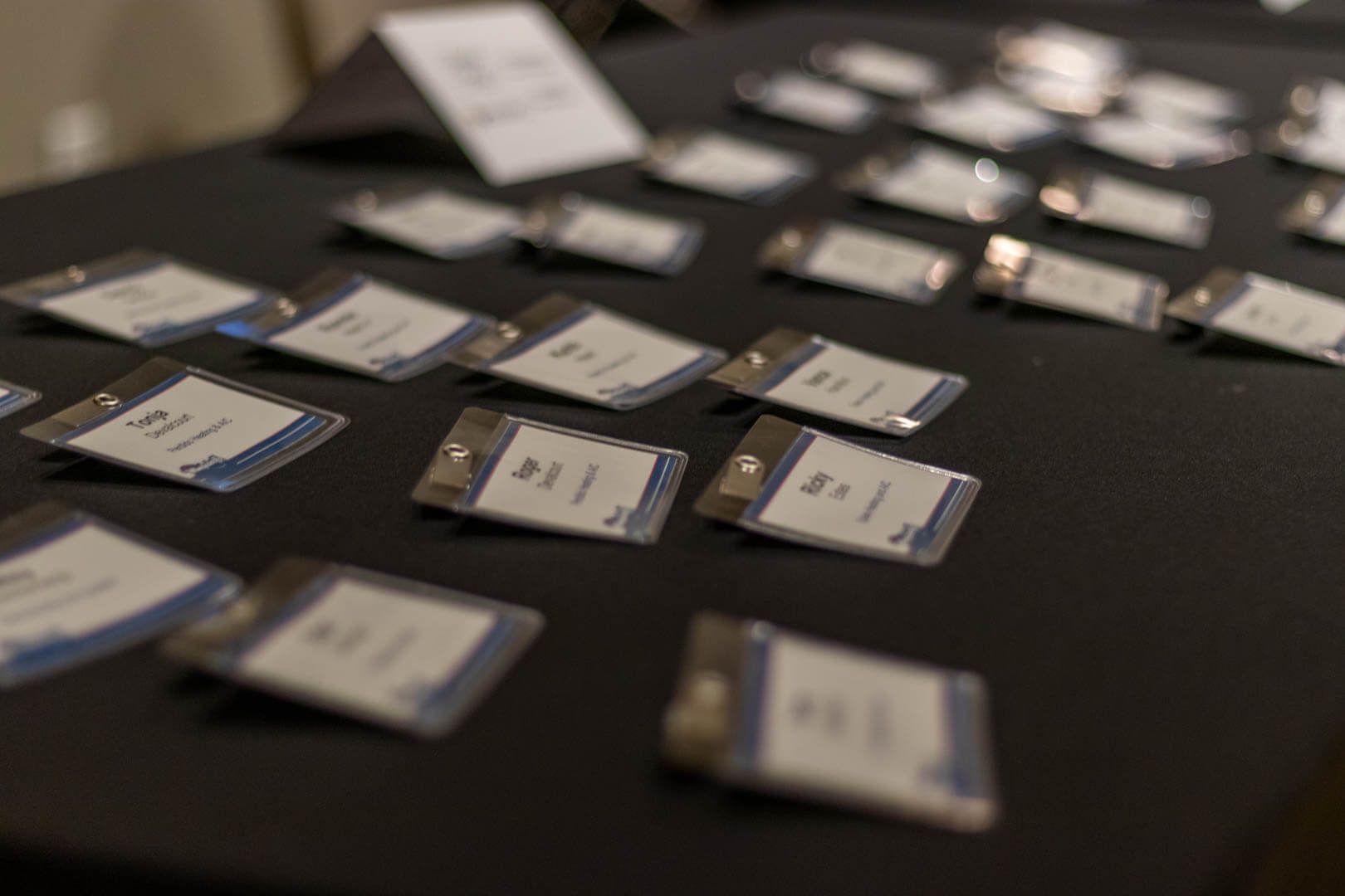 Scattered name badges on a black table at an event registration desk