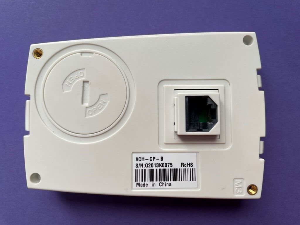 White wall-mounted Ethernet jack plate with a single network port on a purple background